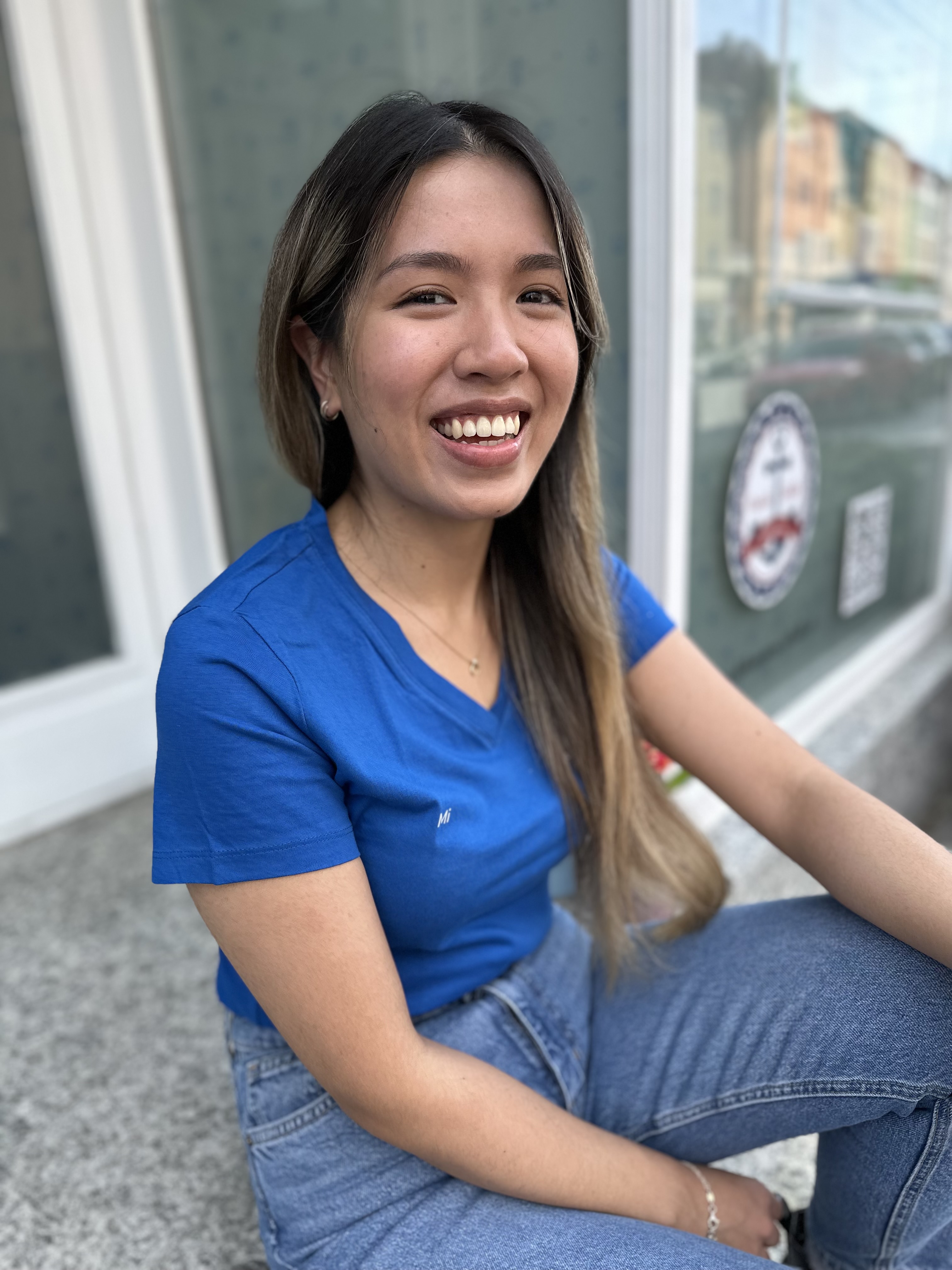 Mi Tran sitzt vor Hebammerei Schaller in Regensburg